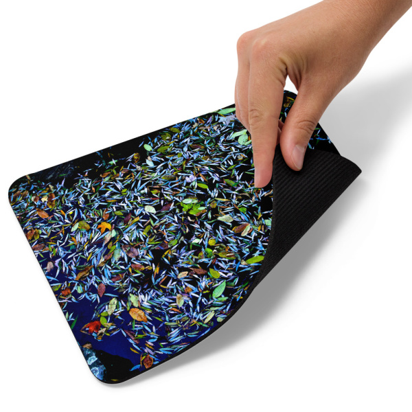 A mouse pad with a photograph of a pond covered with flower petals
