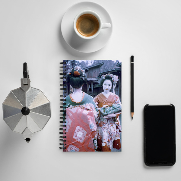 On a table, a Notebook with the photo of Two Japanese Geishas in traditional kimonos