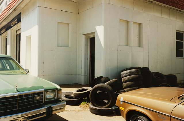 A garage building, with a pile of tires against it and two