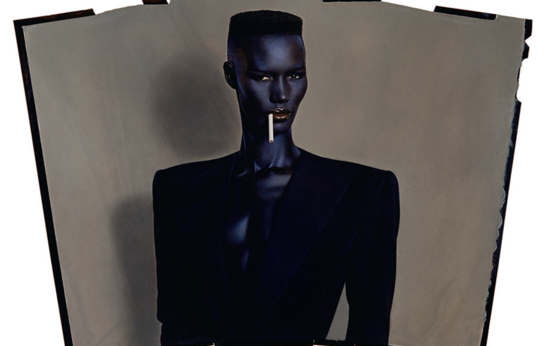 Singer-performer Grace Jones in a sharp tailored jacket, with a cigarette hanging from the corner of her mouth
