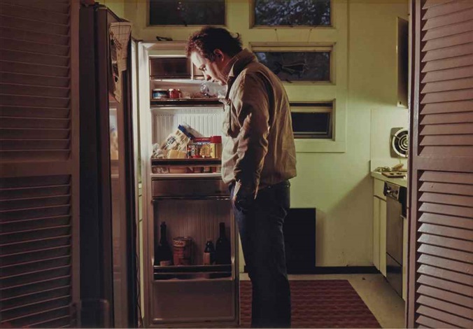 Man looking intently inside his fridge