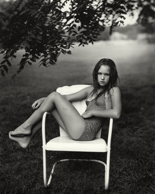12-year-old girl sitting across a chair in a garden