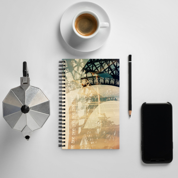 Notebook next to a coffee cup, pen and cell phone