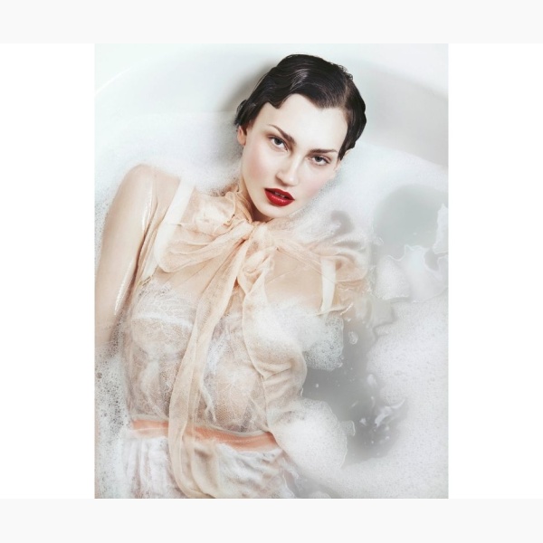 Woman in fancy lingerie, immersed in a bubbly bath, looking at us