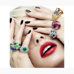 Closeup of a woman, hiding her face with her hands, with huge colorful rings on her fingers