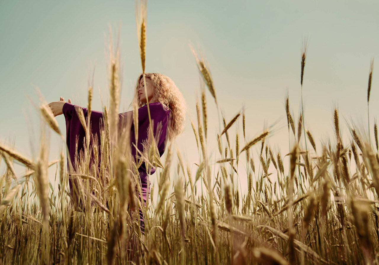 Limited edition print of a woman dancing in a wheat field on a sunny summer day