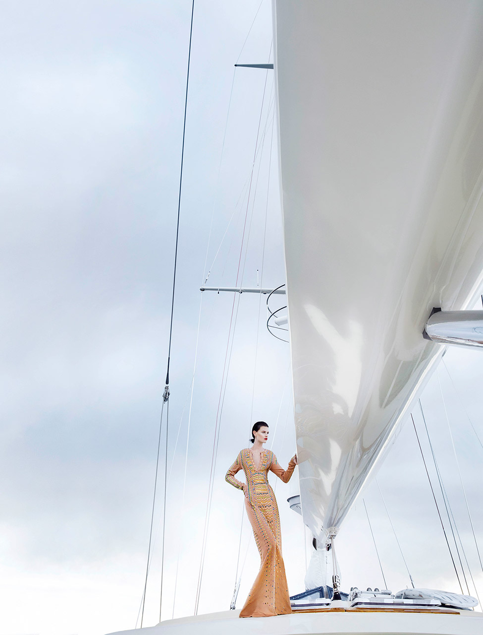 Woman in a long evening gown, standing on a sailboat