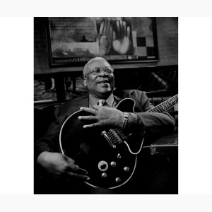 B.B. King holding his guitar, sitting in a club, laughing