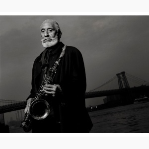 Sonny Rollins holding his saxophone, standing by the Williamsburg Bridge, Brooklyn