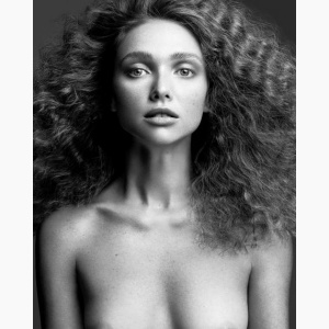 Portrait of a woman, topless, with wild hair, looking straight in the camera