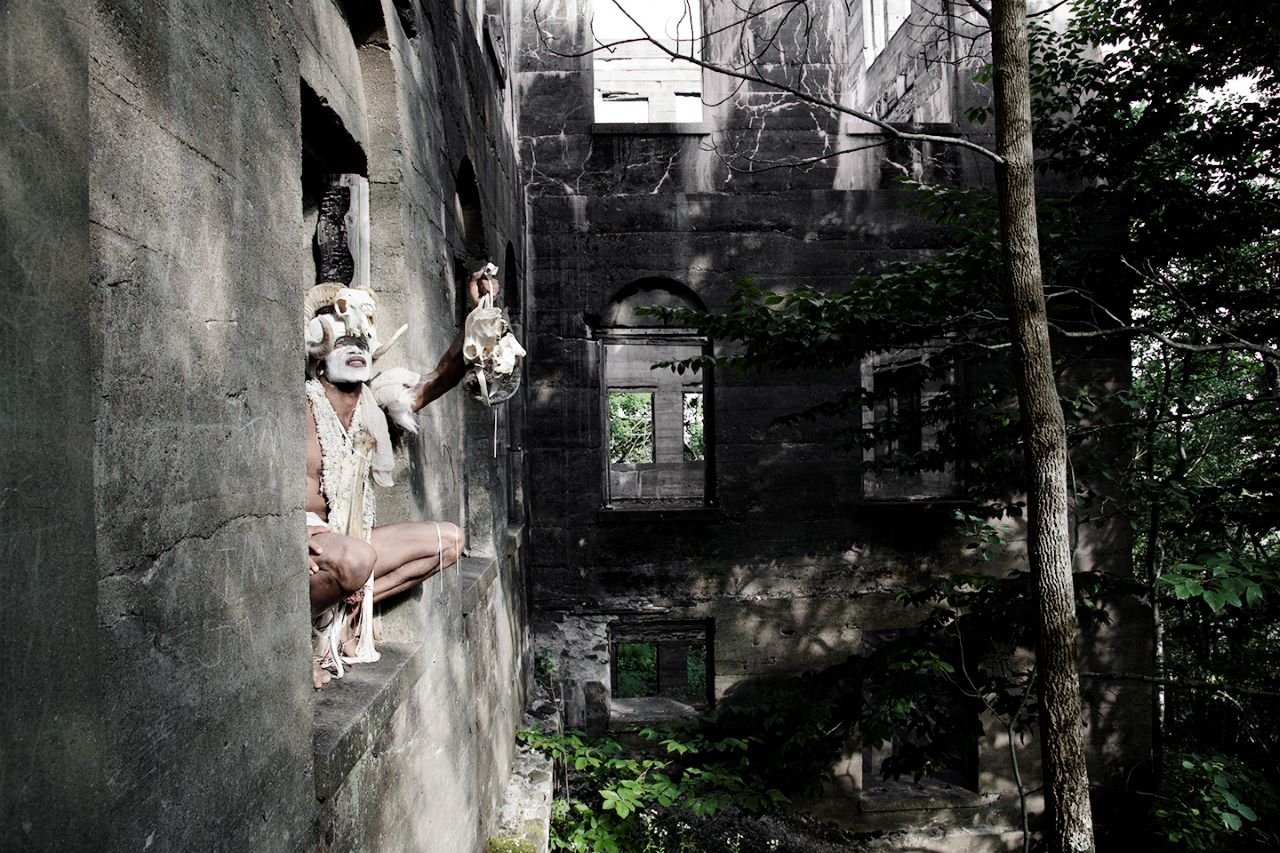 A mysterious man stands guard in an abandoned building