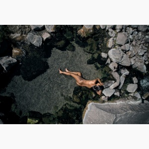 Nude woman seen from above, bathing in a natural spring
