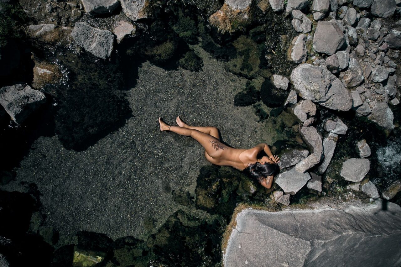 Nude woman seen from above, bathing in a natural spring