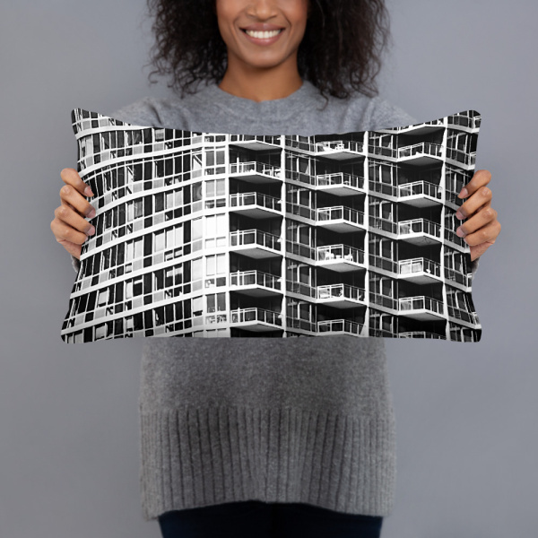 A woman holding a small rectangular pillow with a photograph of a skyscraper façade