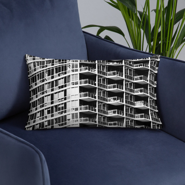 On a chair, a small rectangular pillow with a photograph of a skyscraper façade
