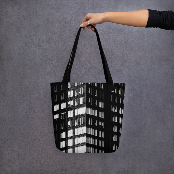 A woman holding a tote bag with a photograph of a skyscraper façade