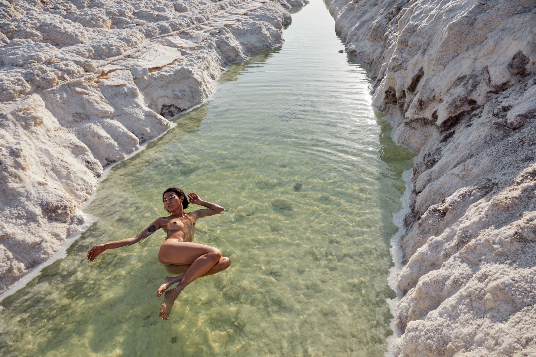 Nude woman floating in a salt lake