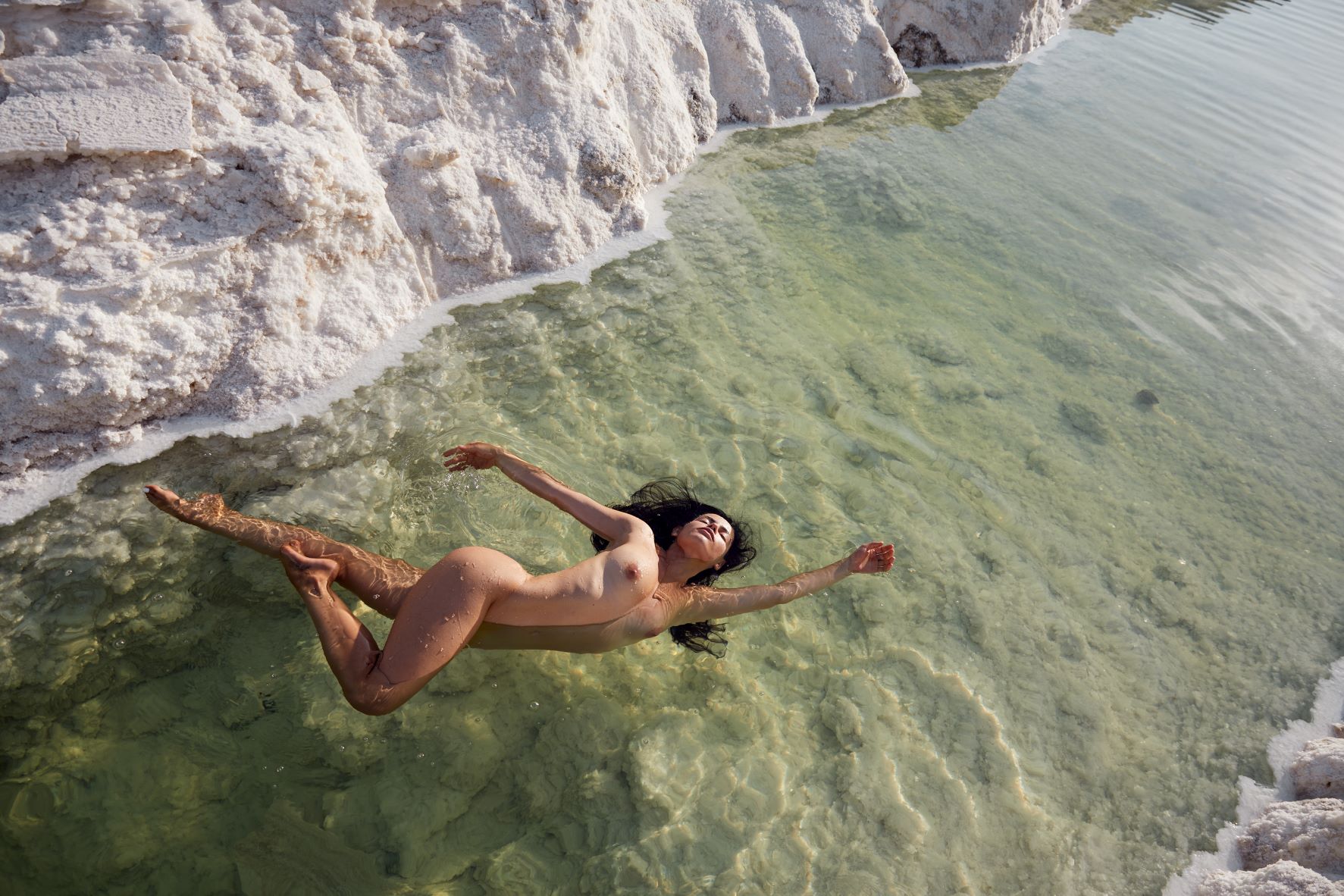 Nude woman floating in a salt lake