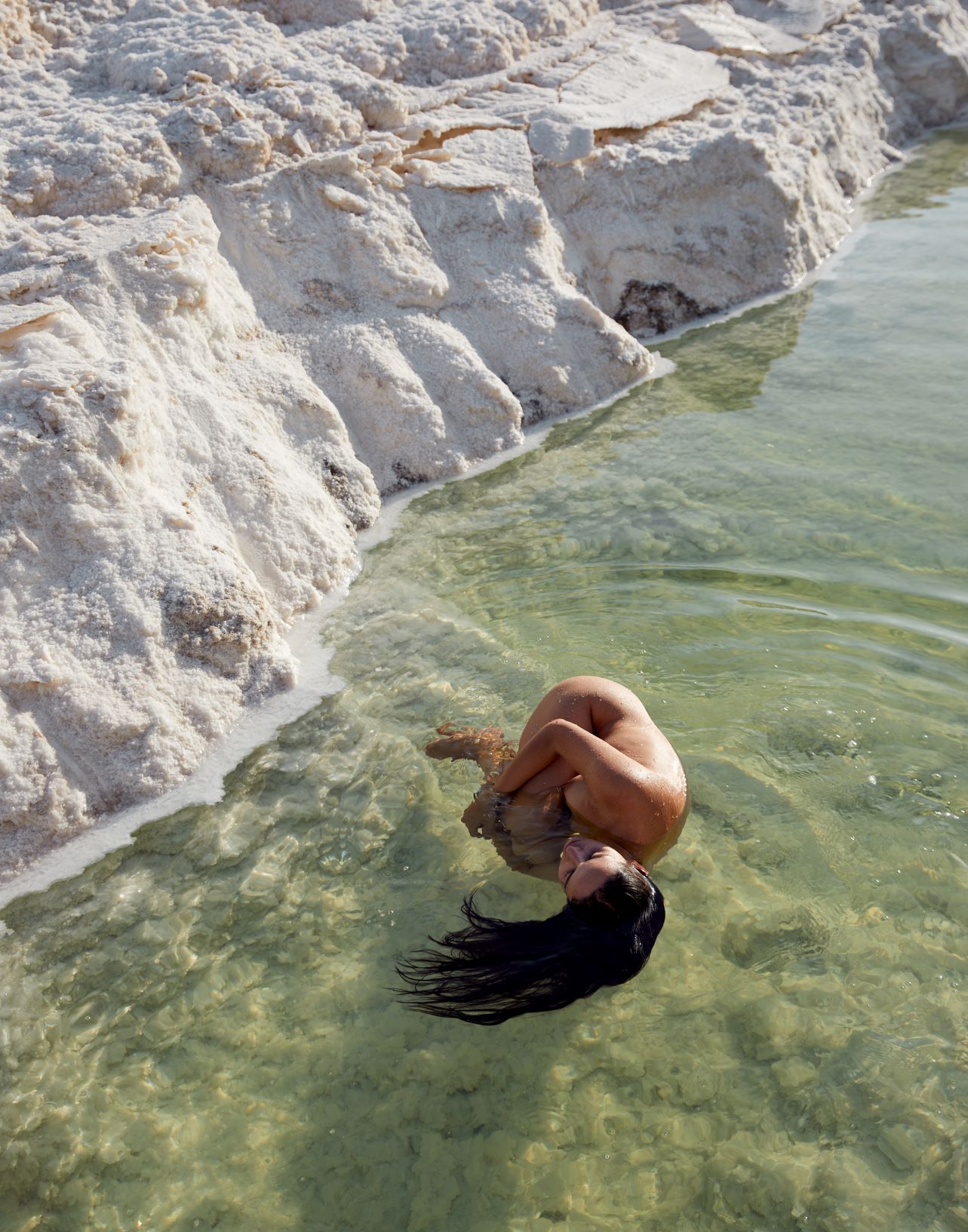 Nude woman floating in a salt lake