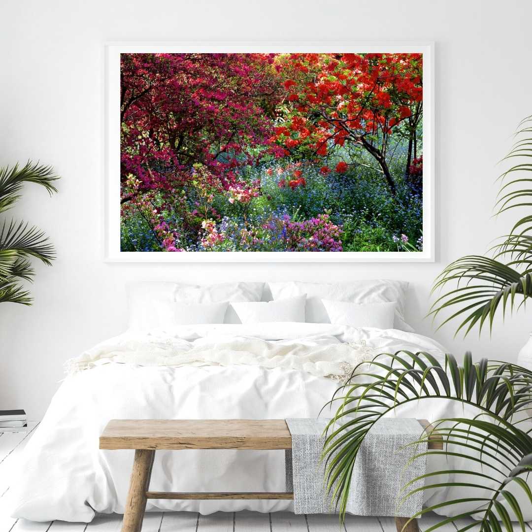 Large framed print of a Mouse pad with a photograph of a shaded and flowery spot in a park, hanging in an all-white bedroom