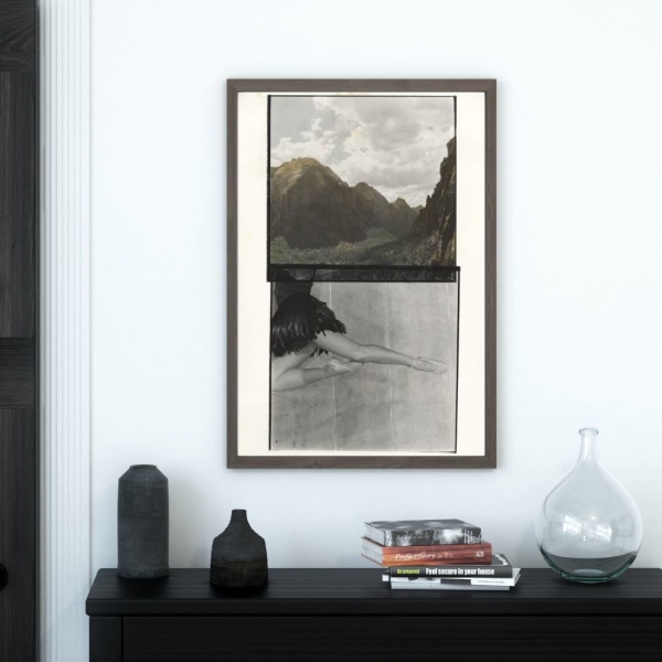 Framed print of a collage print showing a hilly landscape and a leaping dancer, hanging above a console table
