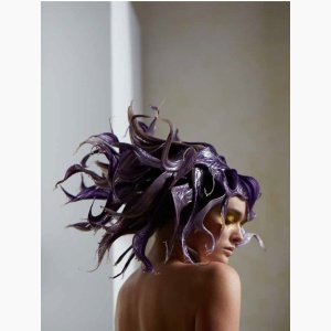 A woman with purple tentacles-like hair hanging in a reading nook corner