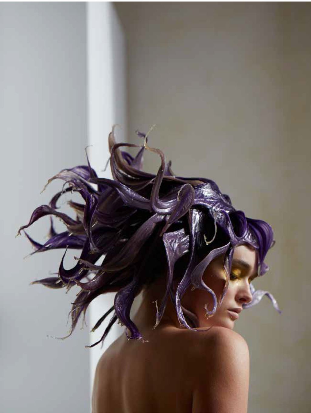 A woman with purple tentacles-like hair hanging in a reading nook corner