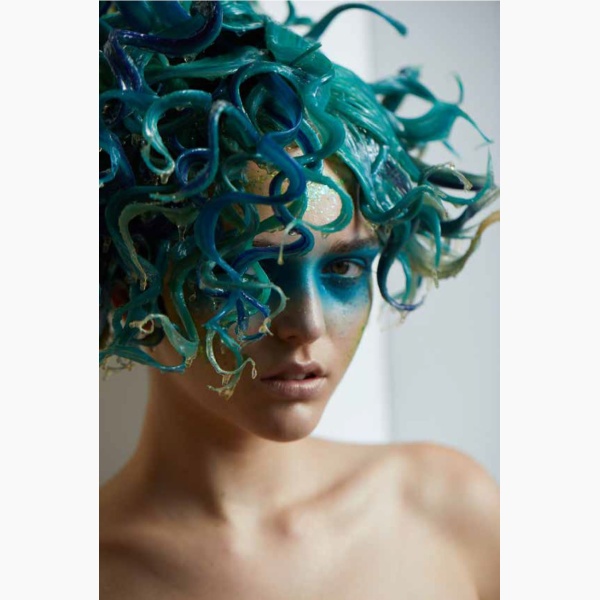 A woman with green tentacles-like hair hanging in a reading nook corner