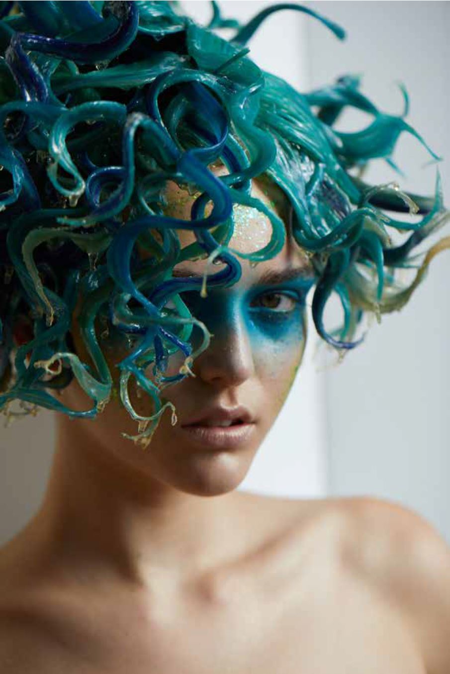 A woman with green tentacles-like hair hanging in a reading nook corner