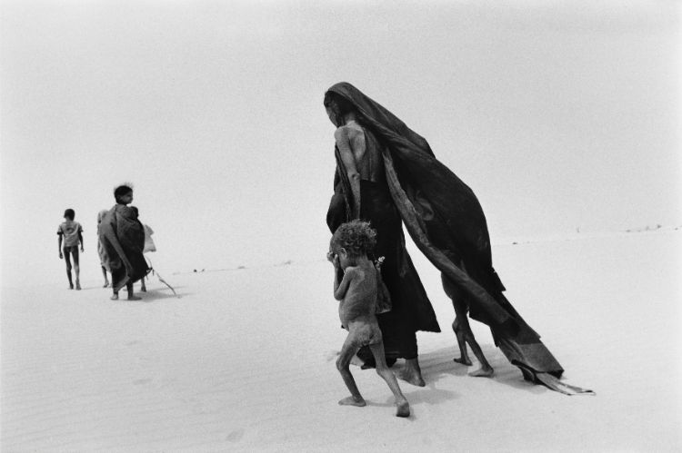 An African family walking in the desert in search of food and help