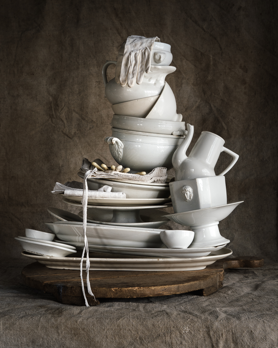 A tall pile of white ceramics sits on a table