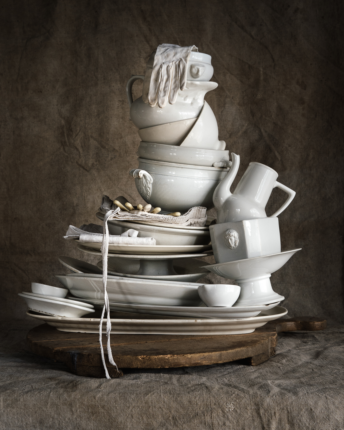 Limited edition print of a tall pile of white ceramics on a table