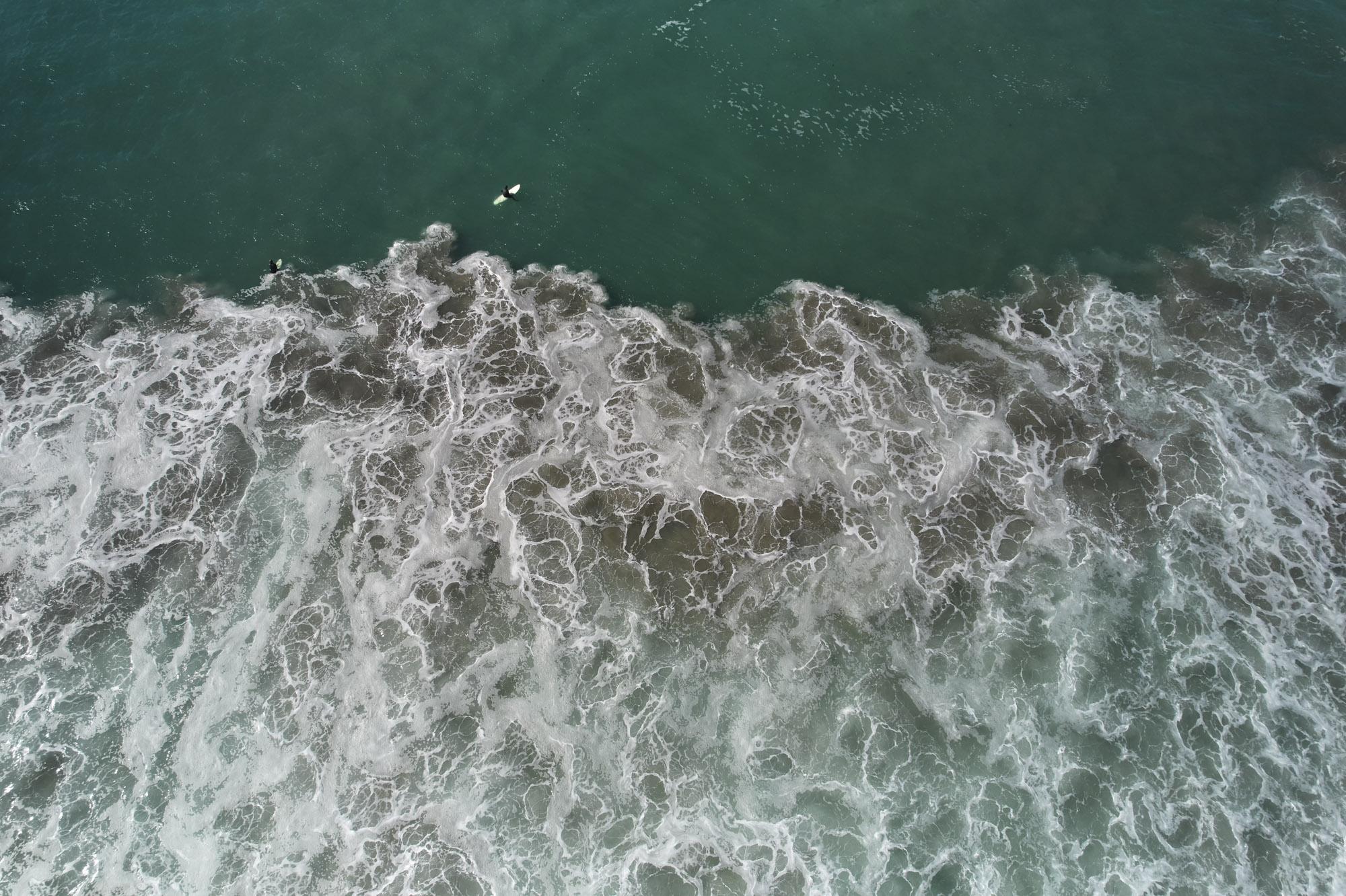 Limited edition print of an aerial photography of two surfers, seen from high above