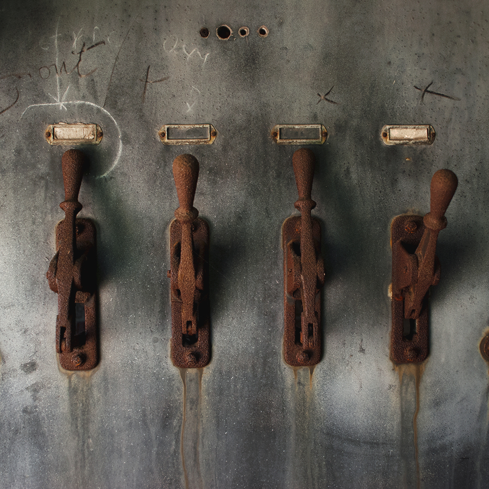 Rusted machinery stand guard in a dilapidated room.